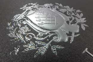 Reliefprägung Silber metallisch auf anthrazitfarbenem Naturkarton für einen Juwelier Detailansicht