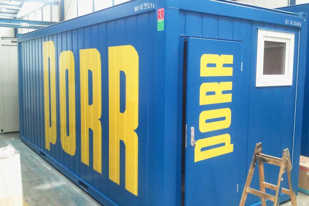 Klebeschrift aus einem Plottertext auf einem Bürocontainer mit Verklebung über Panele mit Sicken